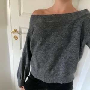 Stickad tröja  - Off shoulder topp i mörk grå. Säljer pågrund av att den inte kommer till användning och är inte riktigt min stil 