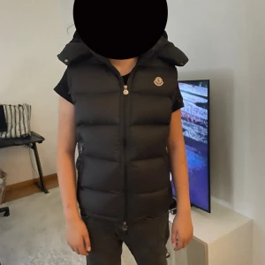 Moncler väst  - Västen är storlek 2 som motsvarar m men passar även s är köpt för 2 månader sen använd 3-4 gånger ej några skador eller något på västen ny stick Luvan går även ta av Scan kod osv finns också 