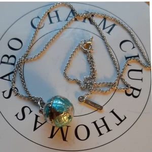 THOMAS SABO HALSKEDJA M BERLOCK.  - Thomas Sabo halskedja ca 43 cm m en fin berlock av ett blått jordklot.  Allt är i fint begagnat skick.  Ask/påse ingår ej.  Kolla bilder o ställ ev frågor före bud.  Frakt tillkommer. 
