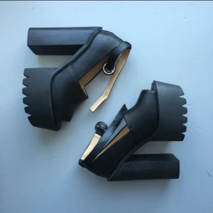  - Svarta chunky heels med platå,  träig rejäl klack,  skinnimitation över själva foten.  oanvända,  endast provade,  överraskande lätta att gå i trots höjden,  tack vare den stabila klacken.