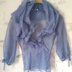  - Elegant och vacker tip i silkesliknande material. färgen är blå och den knyts runt midjan. Toppen är utav ett italienskt märke. 