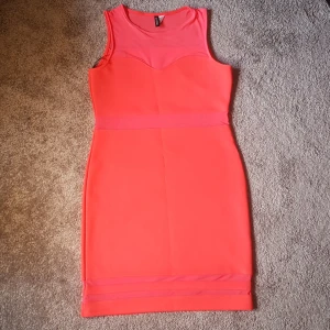 Neon klänning  - Super snygg och formpassande neon klänning. Är i stretchigt material och mesh. Har används en gång och är i nyskick (var inte riktigt min stil). Köparen står för frakt!