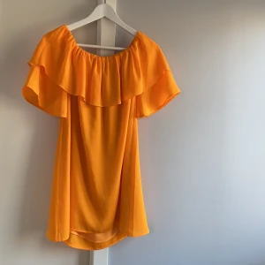 Orange off-shoulderklänning - Från IvyRevel! Använd ett fåtal gånger! Köparen står för frakten