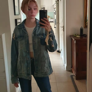Jeansjacka  - Ljusblå jeansjacka med slitningar och snören som håller ihop delarna. Från zara, nästan oanvänd. Frakt tillkommer, kan även mötas upp i Stockholm.