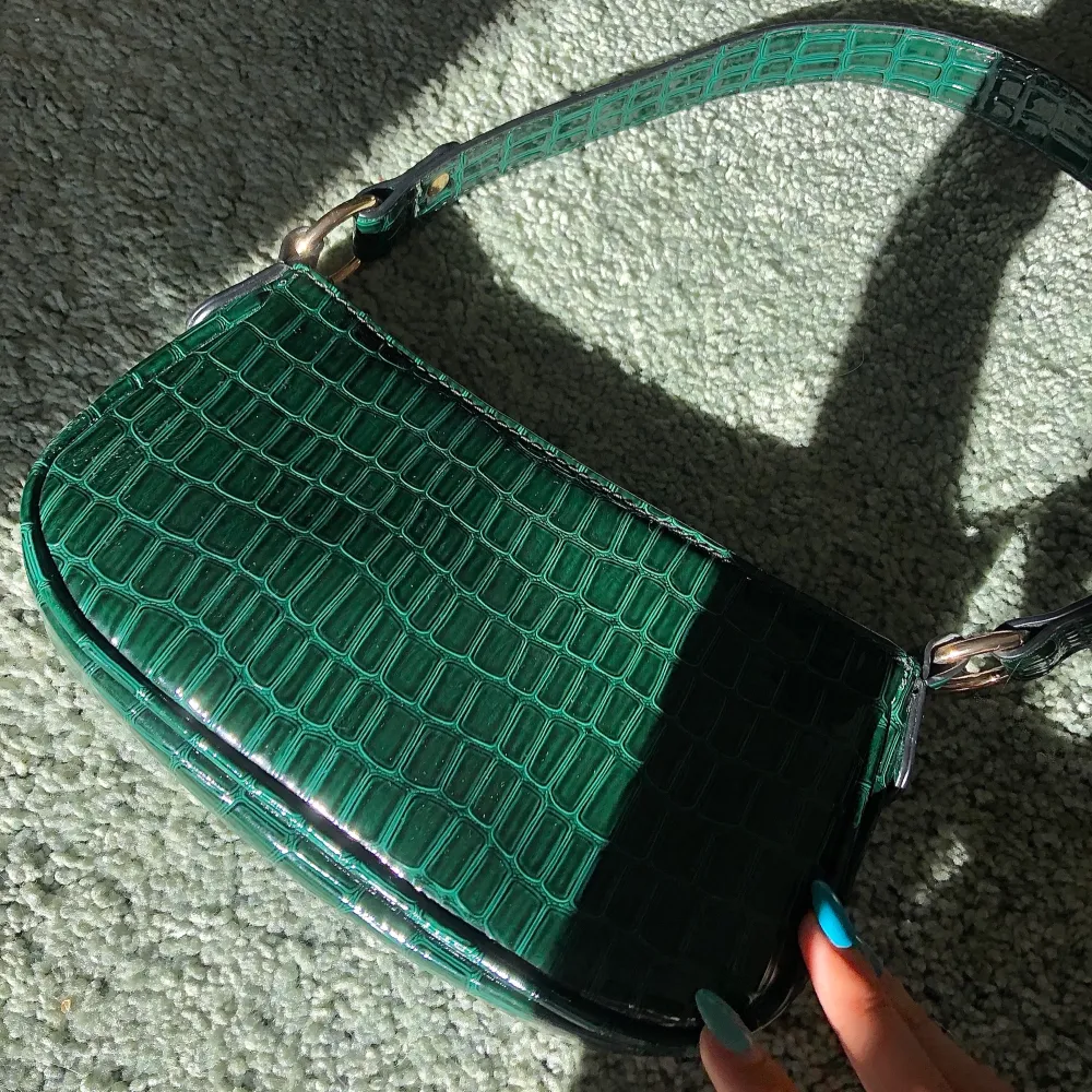 Liten grön väska i fake ”ormskinn”. Väldigt fin och bra skick men använder aldrig🖤. Väskor.