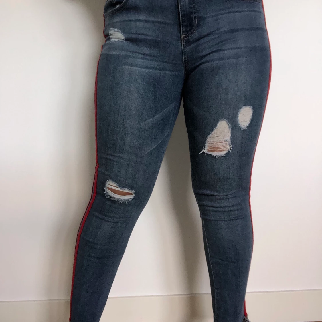 Lätt ripped jeans med röd detalj