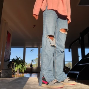 Blåa slitna jeans med slits - Ett par superfina jeans med hål och slits. Dom är från pull&bear men säljs inte längre, bra skick! Har normalt strl 32/34 men har 38 i dessa för en baggy look, as snyggt💗💗 frakten ligger på 64 kr  (bud på 400)