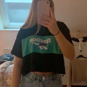 Topp från Reebok  - Cool t-shirt från Reebok med tryckt runt om hela, något kortare. Nästan aldrig använd kanske 2-3 gånger. Mycket fint skick, säljer pga att jag inte har användning för den tyvärr. Tröjan är i S men är något ocersized. Köpare står för frakten 😁