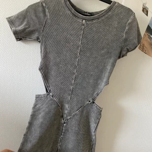 Unik grå klänning med cut out i midjan - Cool, men tyvärr inte min stil! Aldrig använd!