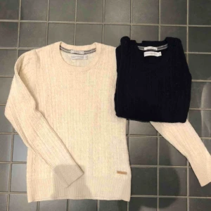  - Två kabelstickade tröjor från Peak Performance i lammull. En mörkblå och en vit/biege. Stretchig kvalitet så passar även storlek S. Tröjorna är nästan helt oanvända och i mycket bra skick!   Säljer dem för 200 kr/styck 