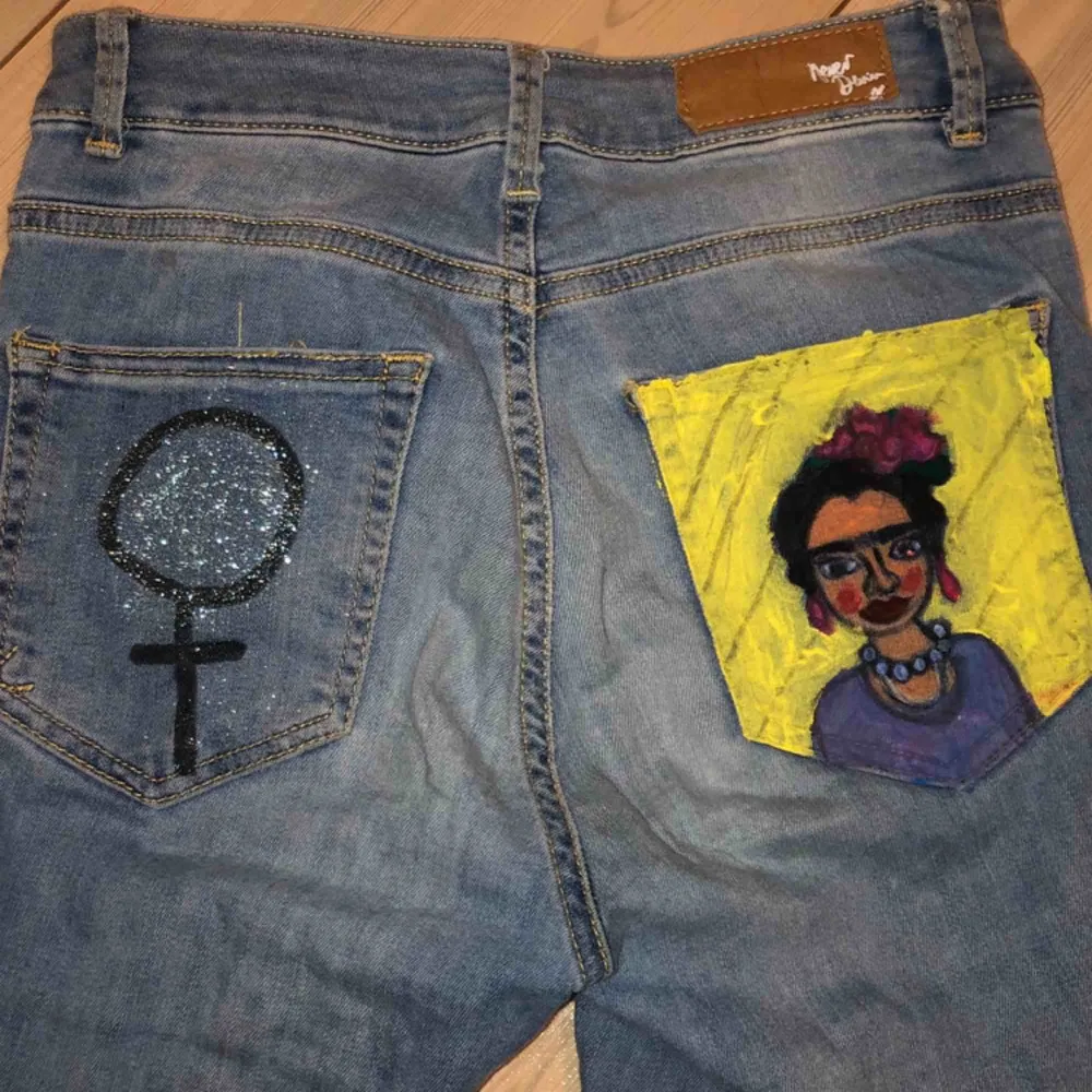 Reworked jeans med Frida Kahlo och kvinnosymbol på fickorna. Storlek XS/S. Frakt tillkommer . Jeans & Byxor.