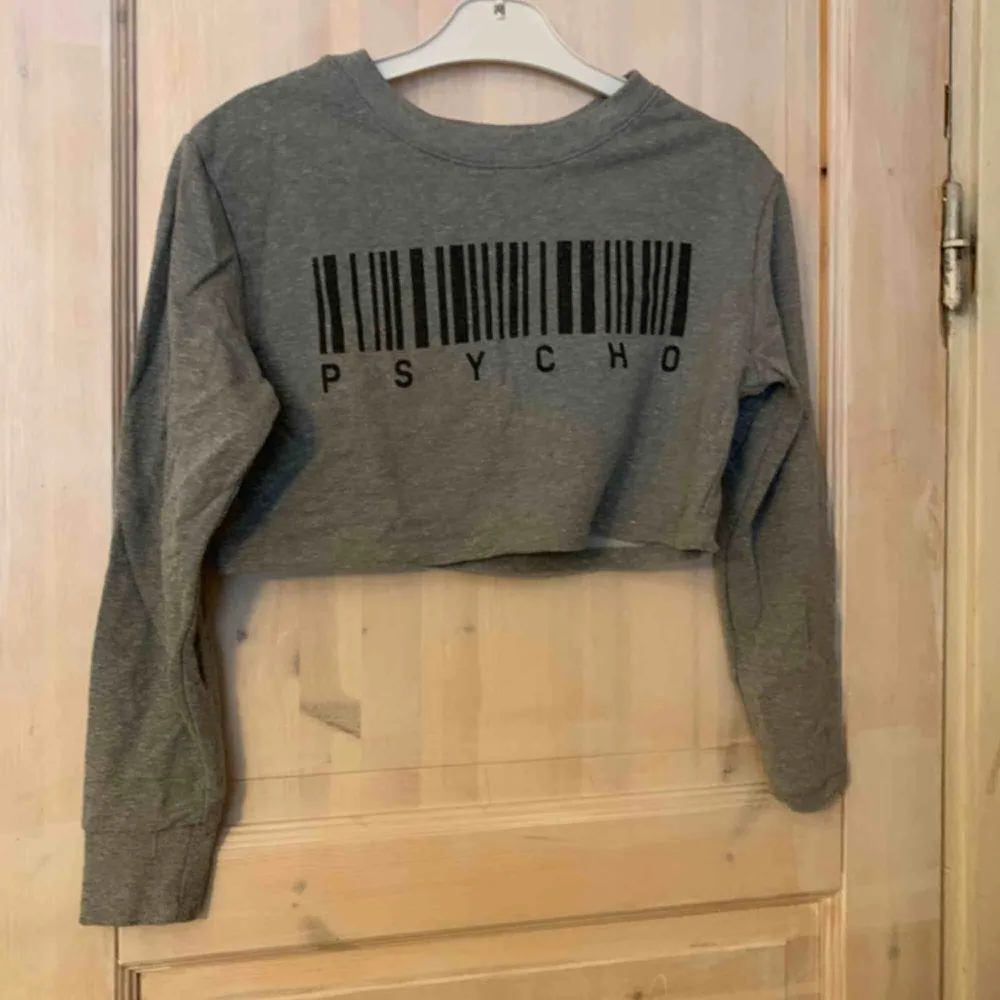 Crop top från Uniqlo inköpt i Japan. Använd men gott skick! Uppskattar den till M men sitter lite lösare på mig som är en S. PASSAR Även större byst (har E kupa själv)  Grått tyg med PSYCHO tryck på. GRATIS FRAKT!. Tröjor & Koftor.