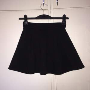 Svart klockad kjol från H&M. Tyget har en viss karaktär (se sista bilden). Strl 34.