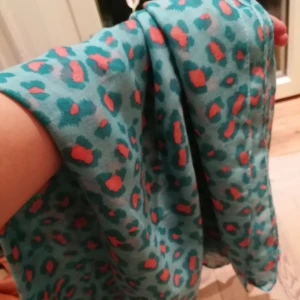  - Stor sjal i leopardmönstrat. Rosa o turkost/ljusblå. Riktigt snygg på sommaren eller som badsarong. 