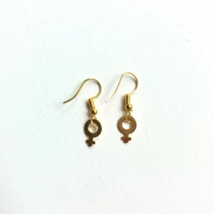  - Guldpläterade och nickelfria örhängen. Kvinnosymbolerna är ca 1 cm stora.