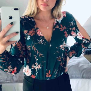  - Grön blus med blommiga detaljer från Nelly. Aldrig använd. Storlek XS.