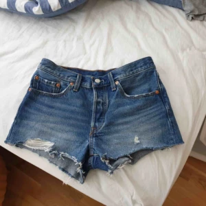  - Helt nya Levis 501 shorts i stl 26. Inköpte på Levis butik (kvittot finns), använd 1 gång och tvättade 1 gång. Tyvärr det visade sig att de är för stora på mig.   Möjlighet att hämta i Uppsala, annars skickar mot fraktkostnad