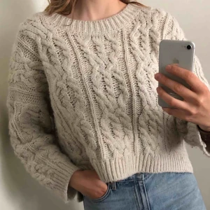  - Gräddvit/beige kabelstickad tröja i lite croppad modell! Superfin och i gott skick, knappt använd. Frakt: 40kr. För mer info se min profil eller skriv!