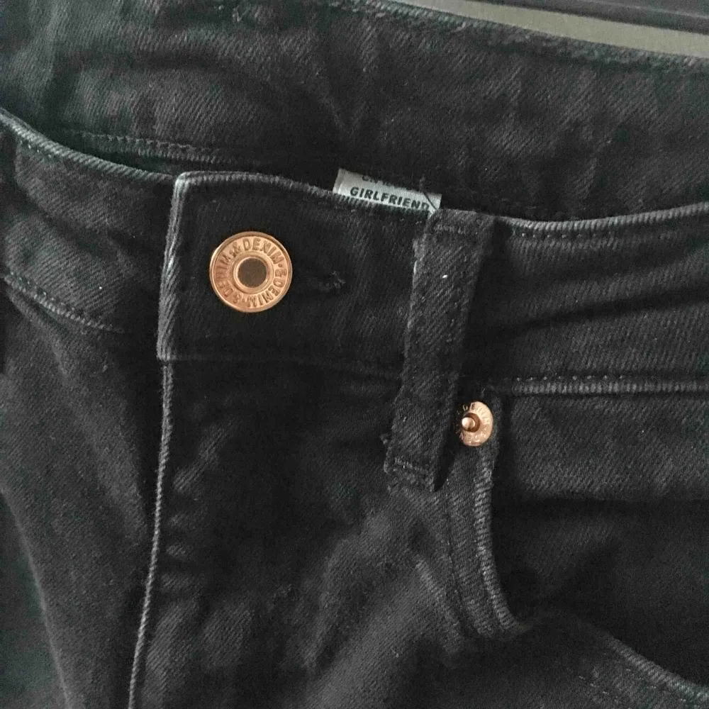Svarta Girlfriend jeans med kopparfärgade detaljer från HM. Passar XS. Skickar gärna men köparen står för frakt.. Jeans & Byxor.