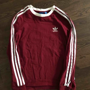  - Populär adidas långärmad tröja i mörkröd. Tröjan är använda max 2 gånger!🌟