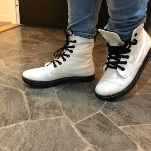 dr.martens tyg vita  - Storlek 38 använda ett par gånger men försmå tyvärr. Älskar dom så om någon har dom i 39 så hojta ! Vita I tyg. 7 hål. Lite smidigare modell än de vanliga kängorna ! En blandning mellan converse och marten typ ;) 