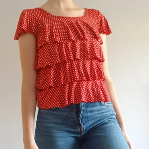 Röd volangtopp - Röd vollangtopp i ca storlek S. Verkligen unik. Supersött och superenkel att vika upp till en croptop. Volangerna sitter så skulle man vilja göra det permanent är det bara att klippa, inga sömmar krävs. Helt ärligt är den inte av särskilt bra kvalitet (sr bild 3), men den ser supersöt ut och jag säljer den för bara 29kr exklusive frakt (44kr). Bjuder dock på frakten vid köp över 300kr. Skriv i dm vid intresse eller för frågor! ❤️