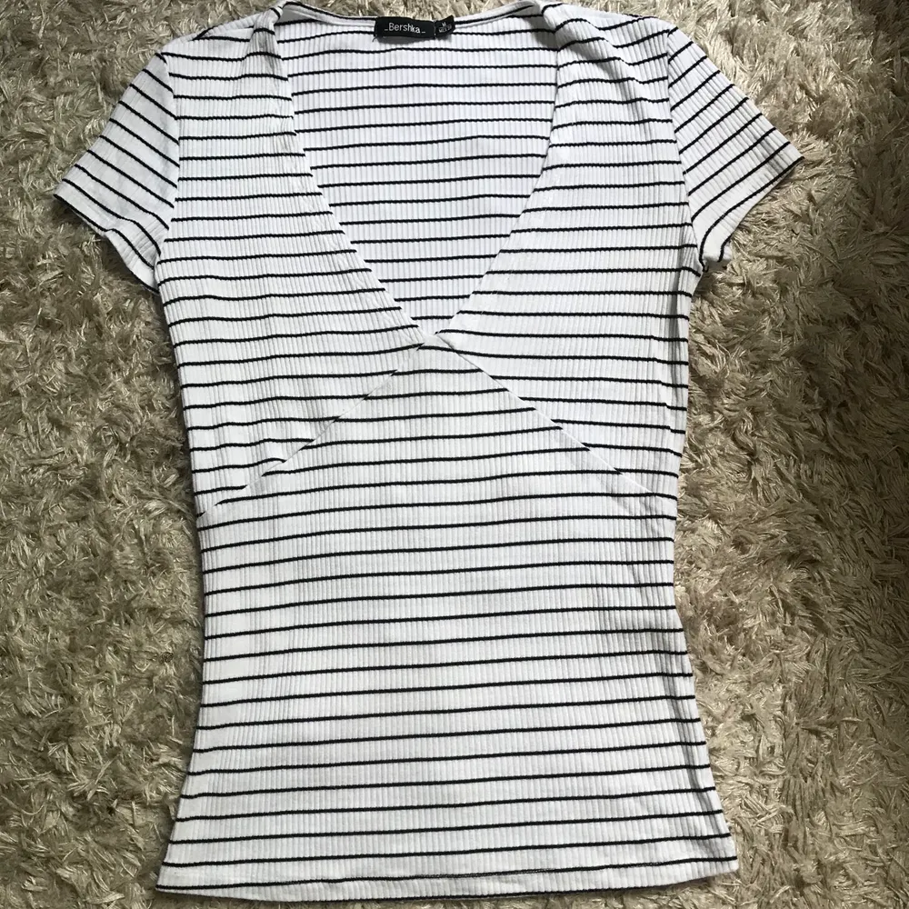 Riktigt snygg minimalistiskt-shirt från Bershka. Superfina detaljer vid brösten. Endast använd ett fåtal gånger och är därför i toppskick! T-shirten är i storlek M men passar XS-M 💛. T-shirts.
