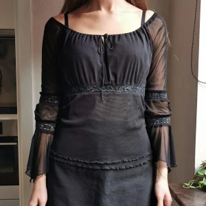 Off Shoulder topp med trumpetärm - Magisk off shoulder-topp i svart mesh. Plagget har härliga trumpetärmar som ger en härlig witchy vibe. Köpt på humana och kommer tyvärr inte till användning så ofta längre. Kan mötas upp i Gbg eller frakta (50kr).