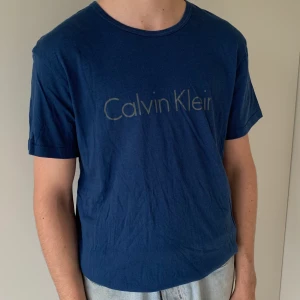 Blå CALVIN KLEIN T-shirt - Säljer denna mörkblåa CALVIN KLEIN i storlek S. Fint skick, använd fåtal gånger. Spårbar frakt tillkommer på 63 kr