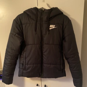 Nike jacka - Fint skick, använd fåtal gånger. Vändbar, på den glansiga sidan finns nikemärke på ryggen.Frakt tillkommer. Nypris: 1099kr  