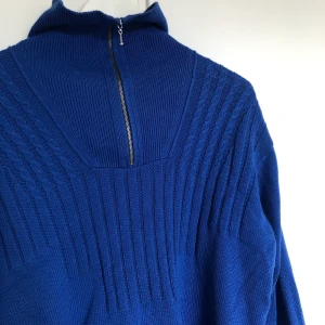 Kornblå stickad tjocktröja  - En kornblå tjocktröja med dragkedja. Storlek: L. Frakt: 63 kr med spårbart postnord. SAMFRAKTAR