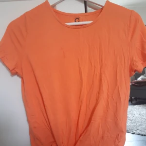 Orange T-shirt - En Orange t-shirt med rosett, knappt använd. Möts i sundsvall elr går köparen för frakt