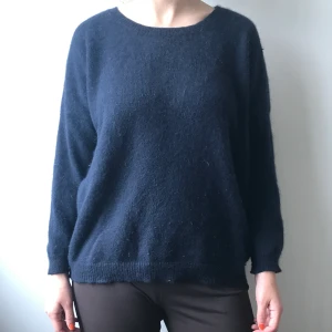 Mörkblå varm tröja angora - Mörkblå stickad tröja i 60% angora och 30% polyamid från Weekday. Storlek L men sitter fint på mig som är S. Tröjan är lite noppig men inget som inte går att fixa. Finns ett litet hål vid vänster axel, men syns knappt och lätt att laga! Superfin och varm!