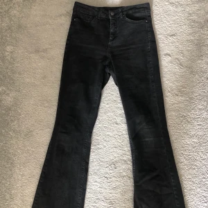 Svara bootcut jeans - Säljer ett par svarta bootcut jeans från Vero Moda. Sitter bra och är lite högmidjade. Jag är 163 cm lång. Byxorna är svarta/urtvättade, vilket är så snyggt på jeans. Använt fåtal gånger. Nypris 350 kr. 