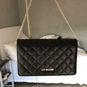 Love moschino väska - Säljer min love moschino väska i svart fake läder. Nypris 1199 kr jag säljer för 350 kr + frakt Väska är i nyskick å endast använd ett fåtal gånger. Priset går att diskutera