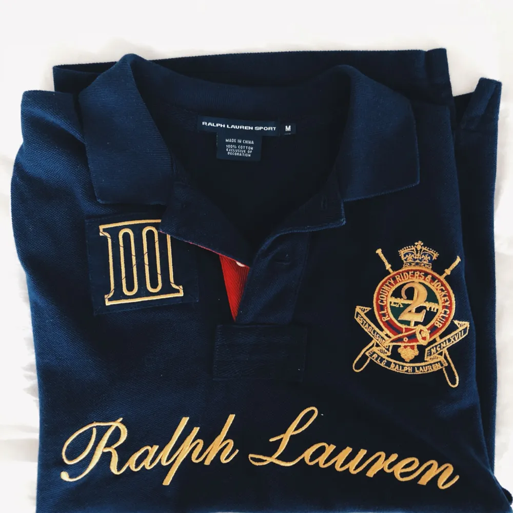 Ralph Lauren sport piké tröja i färgen mörkblå med guld detaljer. Inköpt i USA. Storlek M men skulle vilja säga att den sitter som en S. Jag står för frakten på detta plagg🎀. T-shirts.