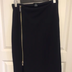 - Svart pennkjol med guldig dragkedja från ellos. Aldrig använd.   Garderobsrensning, se mina övriga annonser. Möjlighet till samfrakt.   Köparen står för frakt. Ansvarar ej för postens ev slarv.