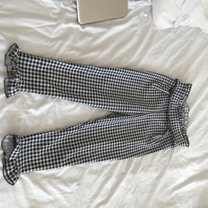  - Rutiga tighta byxor med volanger både i midjan och nedtill.  Köpta från Nelly.com använda en gång endast. Modellen är kort i benen och passar bäst ihop med klackskor. Säljer pga för stora och aldrig tillfälle att använda dem.