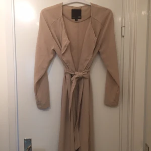 - Längre kappa i beige färg från Lager 157. Oanvänd. 