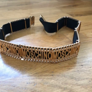  - MOSCHINO-skärp. Aldrig använt. Ej äkta.