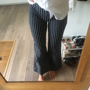 - Säljer svarta byxor strl M jag är 174cm lång byxorna har vita ränder. Postar gärna med blå påsen som tillägg eller möts upp i Stockholm.