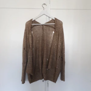  - Kofta med stylade hål i och gulddetaljer