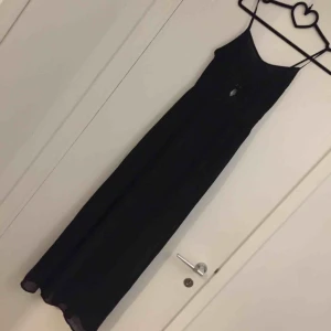  - Svart tunn klänning  En öppning nertill benen 