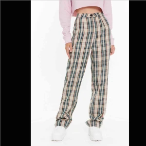  - Rutiga långa byxor som sitter jättebra i rumpan eftersom de inte har stretch. Dom är helt nya och ligger fortfarande i paketet dom kom i! Beställde på nasty gal i strlk 36. Säljer eftersom de är för små. 