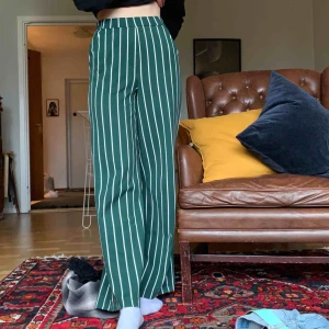  - Raka grön/vit randiga byxor. Resår i midjan. Två fickor.  40kr + frakt 