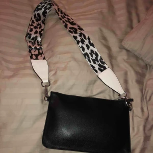  - En svart väska med leopard band. Inte använt. Skriv om du är intresserad! Frakt ingår ej i priset.
