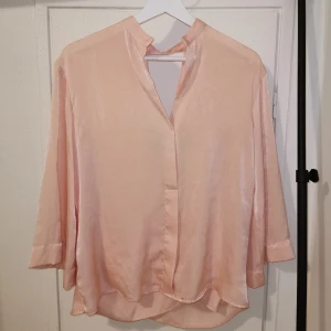 Classy blus 3/4 ärm  - Silkesfin rosa blus med öppen rygg och trekvarts armar. Använd 1 gång. 
