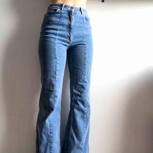 Högmidjade utsvängda blåa jeans med sömmar bak och fram på benen. Köpta på HMs kollektion från förra året, använt några gånger, bra skick! Orginalpris 499kr. Säljer dom för dom är för stora på mig men sitter bra i längden (är170cm) Möts i Stockholm 