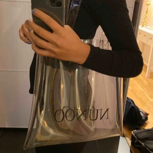  - Genomskinlig väska från Nunoo. Väldigt fin!! Original pris: 349kr. Mitt pris 159kr Köparen står för frakten