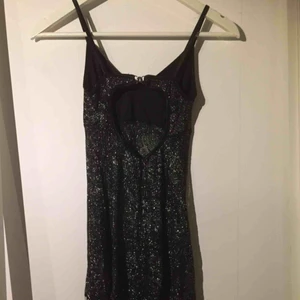  - Jättefin klänning i genomskinligt svart/silver metallic textil. Inte en klänning man har på sig till skolan eller jobbet.... Fransar nertill och fin rygg. Står S, men mera mot xxs/xs. Mycket kort, ca 75 cm inkl fransar.